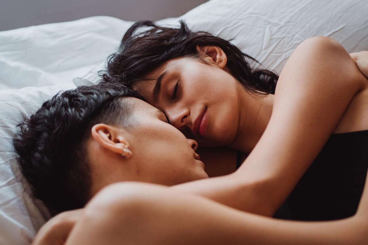 couple allongé dans un lit occupé de se faire un calin